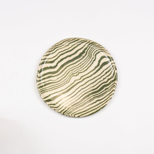 Round ceramic plate with green and beige striped pattern on a white background