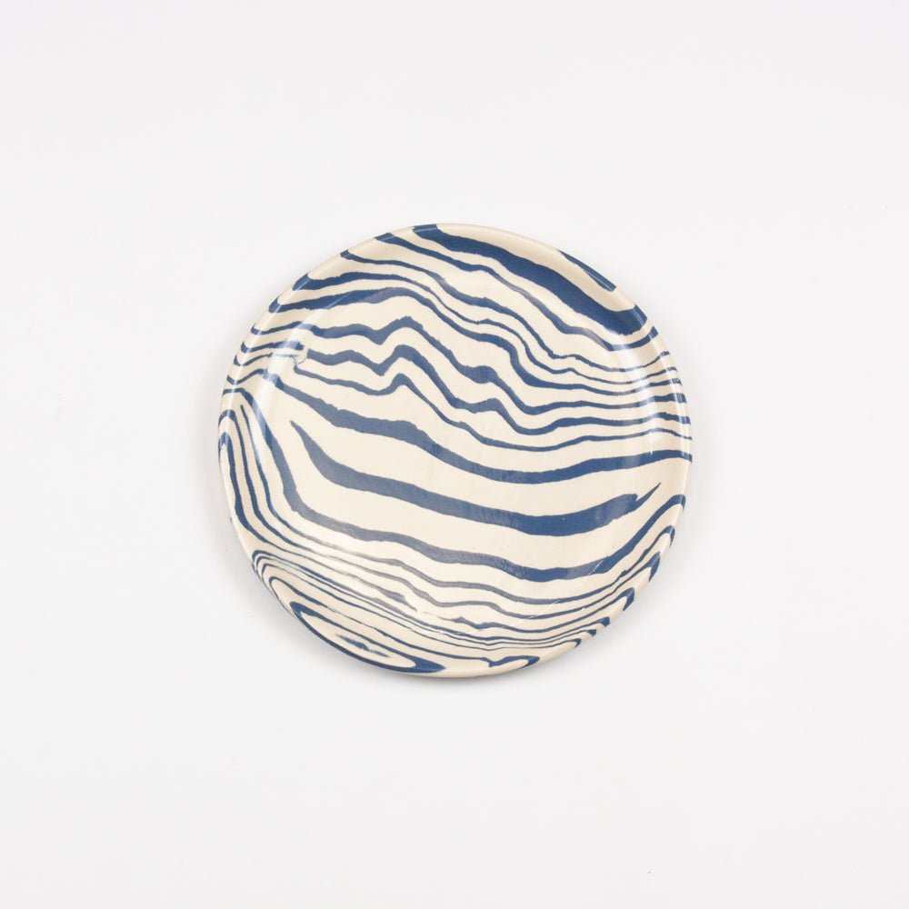 Ceramic plate with blue wavy pattern on a white background