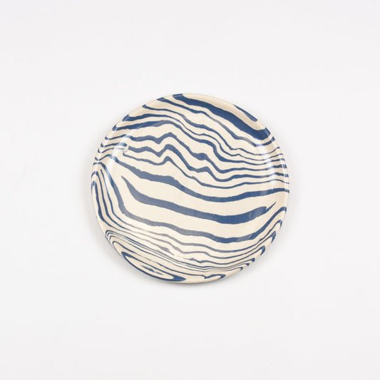 Ceramic plate with blue wavy pattern on a white background