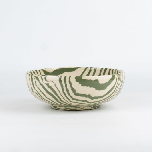 Ceramic bowl with green and white pattern on a white background